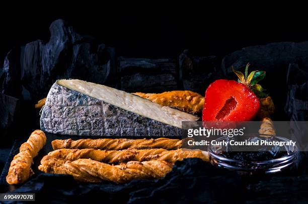 artisanal cheese from cow milk with a covering of fine powdered charcoal served with puff pastry parmesan twists, strawberry and quince jam surrounded with charcoal - powdered milk stock pictures, royalty-free photos & images