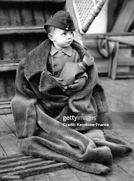 Tony Miller, âgé de 2 ans venant de Singapour avec la Royal Air Force, est photographié à son arrivée à Southampton, emmitouflé dans un manteau,...