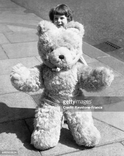 Julie Williams, âgée de 3 ans et demi et élue la plus belle petite fille du Royaume-Uni pose avec un ours en peluche aussi grand qu'elle, à Londres,...