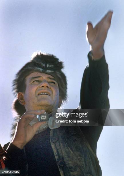 Low-angle view of American actor John Wayne as he directs him film 'The Alamo', Brackettville, Texas, 1960.