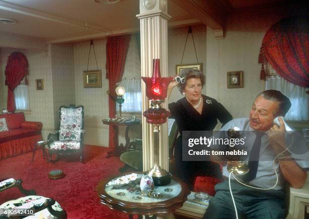 American film producer and studio executive Walt Disney talks on the telephone as his wife, Lillian Disney , watches, Anaheim, California, January...