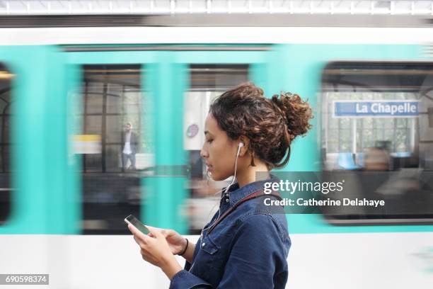 a young woman with a smartphone in the subway of paris - smartphone im zug stock-fotos und bilder