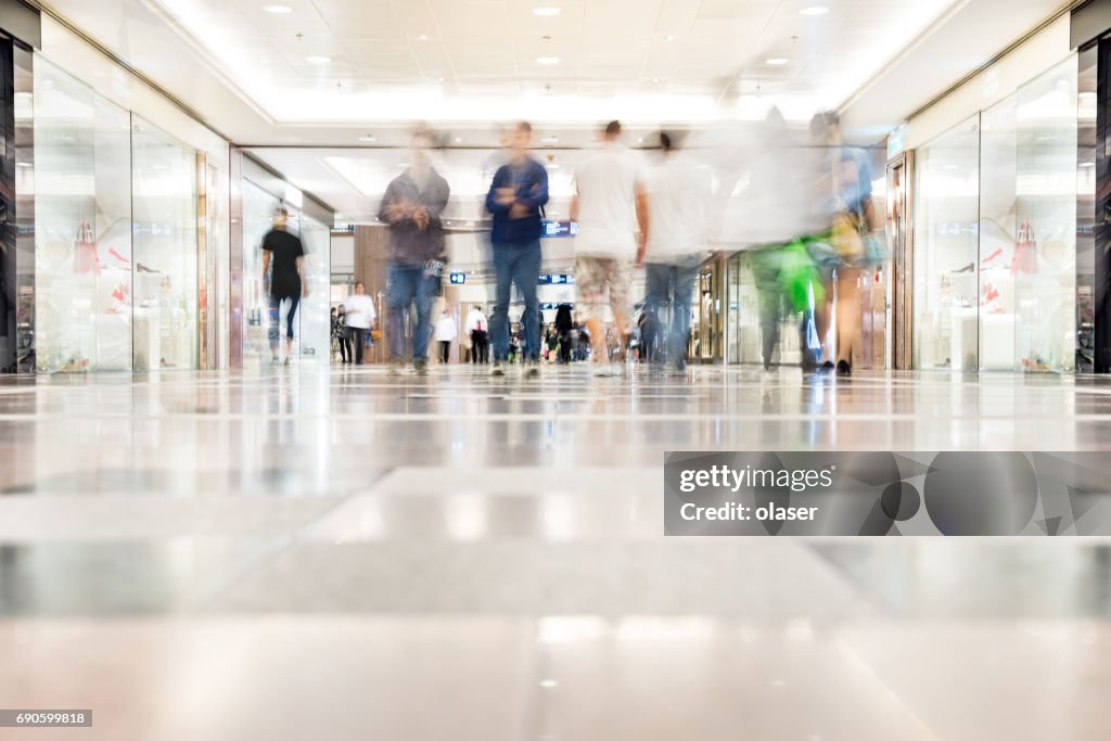 Los clientes en movimiento borroso caminando en un centro comercial, Hong Kong