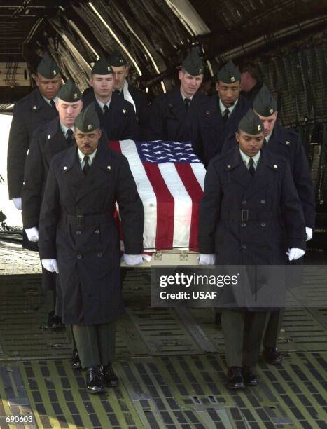 Flag-draped casket containing the remains of U.S. Army Sergeant First Class Nathan Ross Chapman is carried off a U.S. Air Force C-5 aircraft by a...