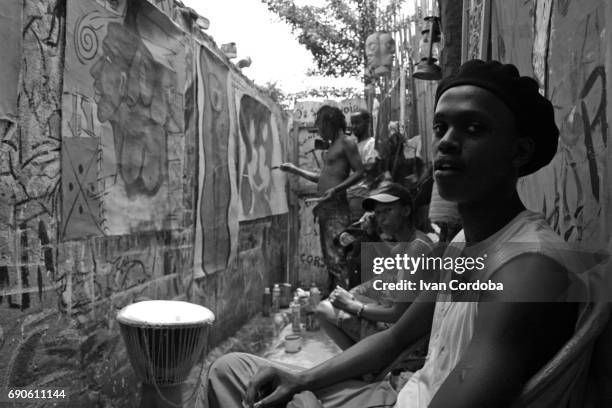 african painter works accompanied by friends at his place in bujumbura, burundi. - eastern african tribal culture stock pictures, royalty-free photos & images