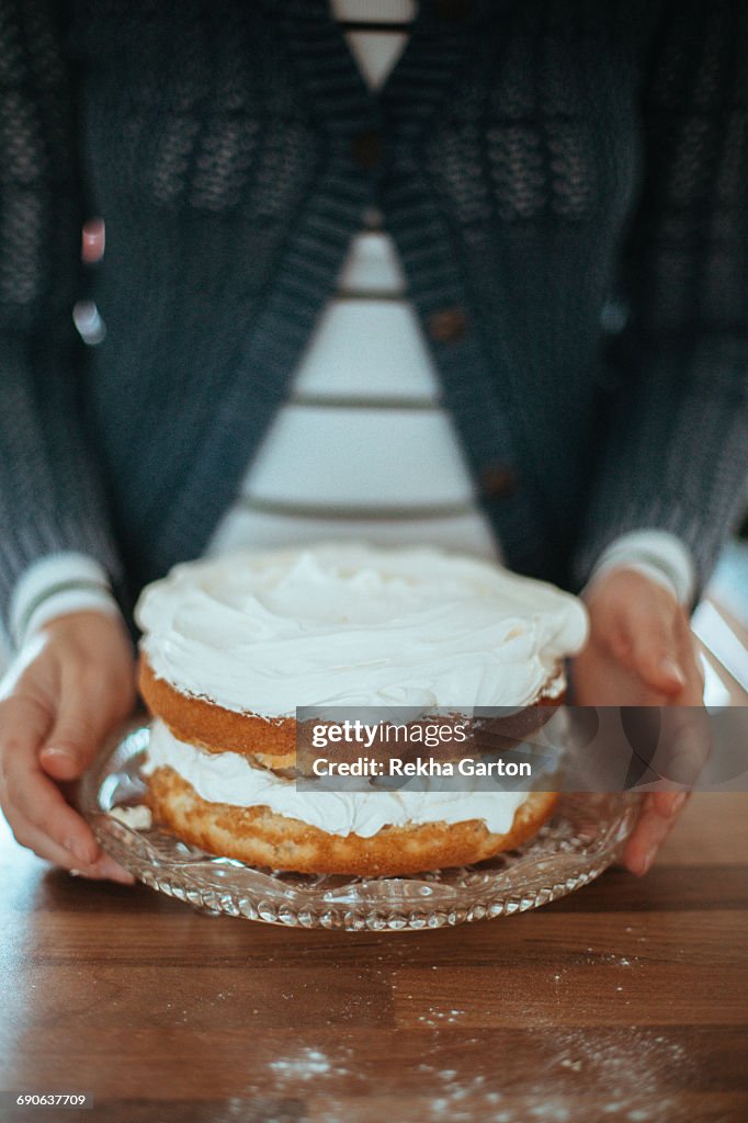 Womans hands holding a cake
