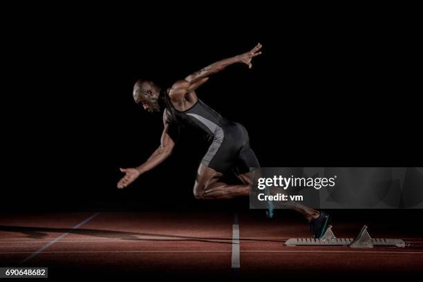 sprinter of african descent starting to run - sprinter stock pictures, royalty-free photos & images