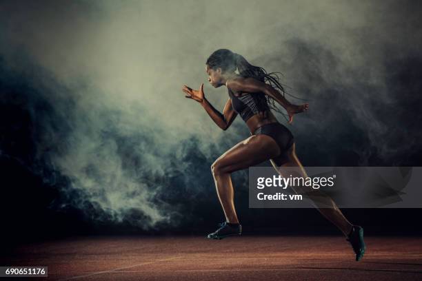female runner of african descent in mid-air - sportsperson stock pictures, royalty-free photos & images