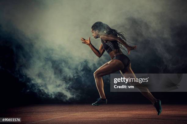 female runner of african descent in mid-air - corrida de velocidade imagens e fotografias de stock