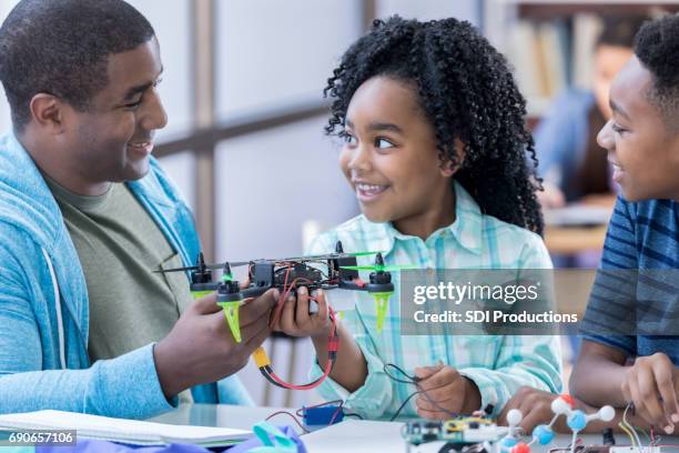 padres voluntarios ayuda a los estudiantes en después de la escuela club de ingeniería - drone kid fotografías e imágenes de stock