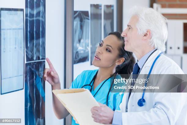 confident radiologists examine patient x-rays - orthopedic surgeon stock pictures, royalty-free photos & images