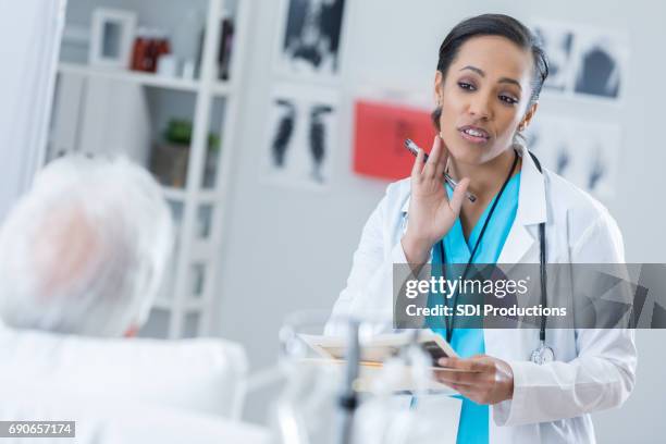 african american female physician talks with patient - human jaw bone stock pictures, royalty-free photos & images