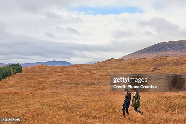 two girls walking in landscape - schotland stockfoto's en -beelden