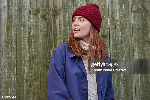 young woman looking over her shoulder - knit hat stock pictures, royalty-free photos & images