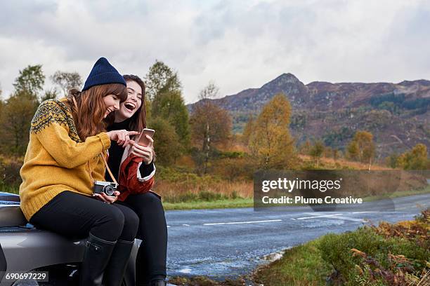 laughing with smartphone - woman smartphone nature stockfoto's en -beelden