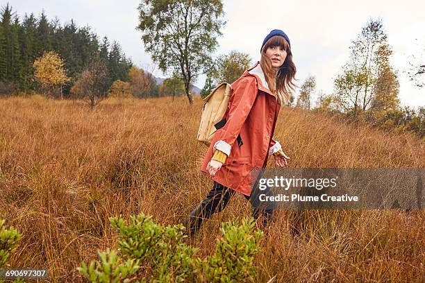 young woman walking in nature - walking side by side stock-fotos und bilder