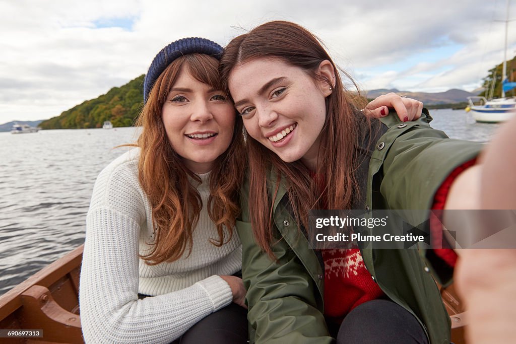 Two friends in a row boat taking a selfie