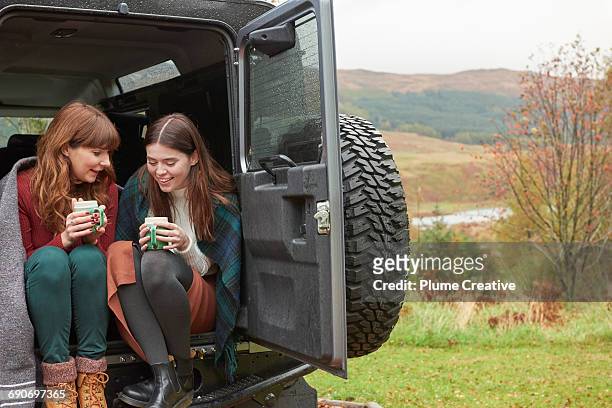 two friends having tea in the back of their car - the fall band stockfoto's en -beelden