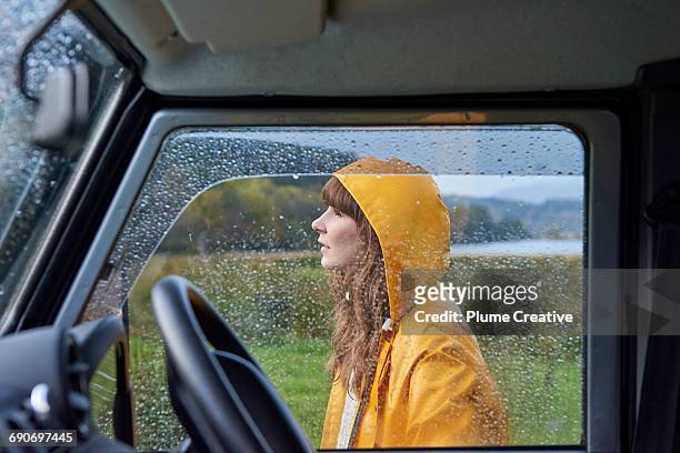 Portrait of woman behind rain covered window