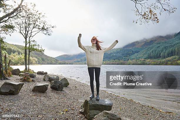 woman laughing by the side of a loch - emotion meer stockfoto's en -beelden