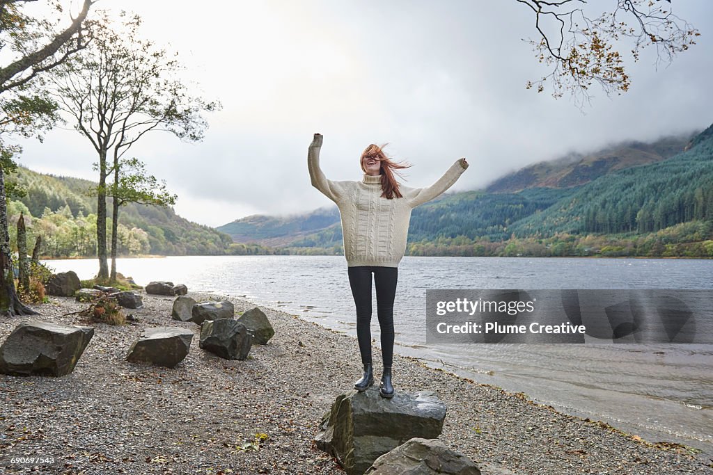 Woman laughing by the side of a loch