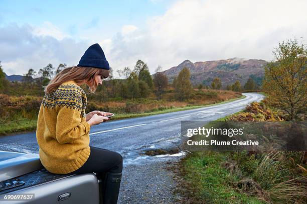 young woman using her phone in nature - knitted car stock pictures, royalty-free photos & images