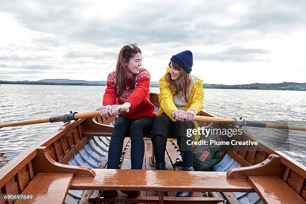 two friends rowing in a boat - teamwork rowing stock pictures, royalty-free photos & images