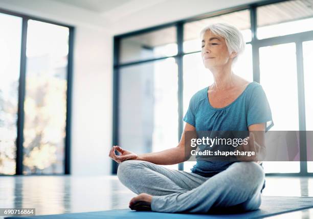 practising mindfulness through yoga and meditation - lotus position stock pictures, royalty-free photos & images
