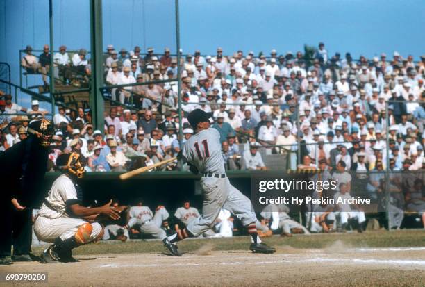 Luis Aparicio of the Chicago White Sox swings at the pitch as catcher Elston Howard of the New York Yankees looks on during an MLB Spring Training...