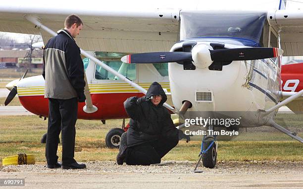 Flight instructor watches a student perform a pre-flight check on a Cessna 172 before leaving the American Flyers Pilot Training School January 7,...