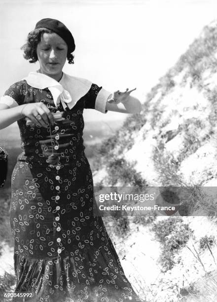 Femme tenant sans ses mains un pendule recherche une source d'eau, à Haute-Isle, France en 1933.