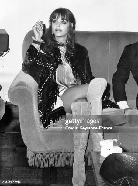 Actrice française Tina Aumont vêtue d'une tenue hippie, très hautes bottes et mini-jupe, photographiée à Rome, Italie le 11 octobre 1968.