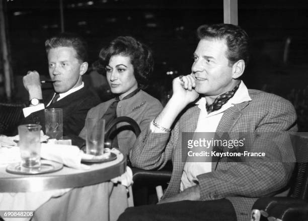 Le producteur de cinéma Jacques Vovis et sa femme Françoise avec Jean-Pierre Aumont photographiés assis à une terrasse de café à Rome, Italie le 23...