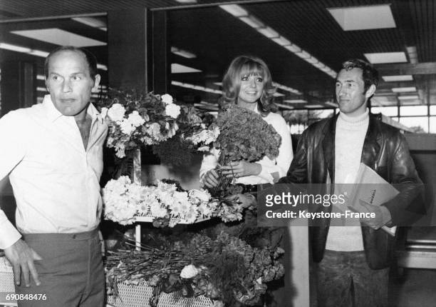 Les acteurs Marcel Bozzuffi et Sylva Koscina et le réalisateur Jean-Pierre Desagnat sur un stand de fleurs en tournage à l'aéroport de Nice en France.
