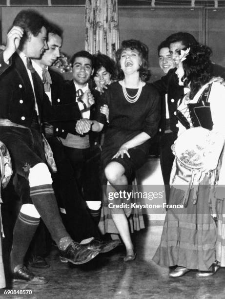 Actrice italienne Sylva Koscina danse et rit avec une troupe de danseurs folkloriques.