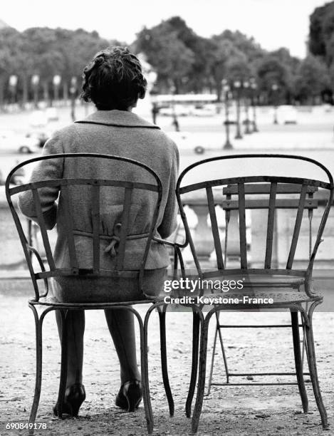 Femme assise seule sur un chaise au Jardin des Tuileries à Paris, France.