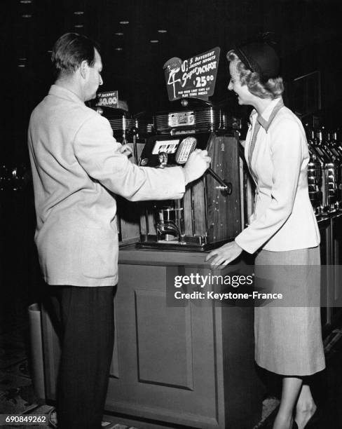 Jeunes mariés jouant aux machines à sous dans un casino de Las Vegas, Nevada, Etats-Unis.
