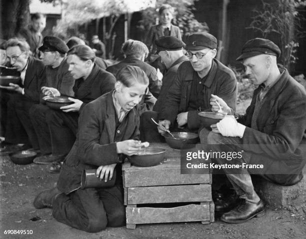 Des mineurs et ouvriers photographiés pendant leur pause déjeuner en plein air durant laquelle ils mangent leur soupe, unique repas de la journée, en...