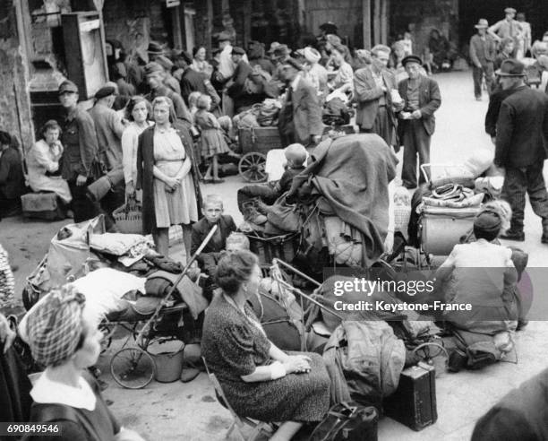 Civils allemands déplacés attendant parmi leurs bagages hétéroclytes l'arrivée d'un train qui les ramènera vers Berlin, en Allemagne le 31 octobre...