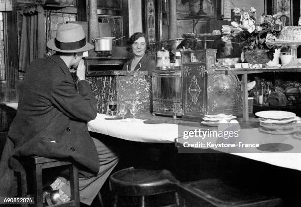 Un client, assis au bar du célèbre restaurant Sheriff, parle avec la caissière, à Londres, Royaume-Uni