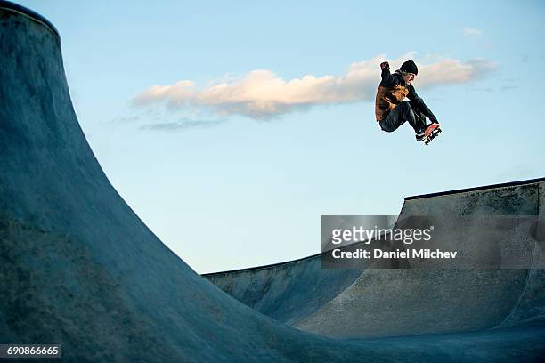 skateboarder jumping at a skate park. - bewegungsaktivität stock-fotos und bilder