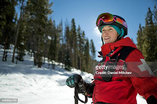 strong female ski patrol smiling on a work day. - colorado skiing stock pictures, royalty-free photos & images