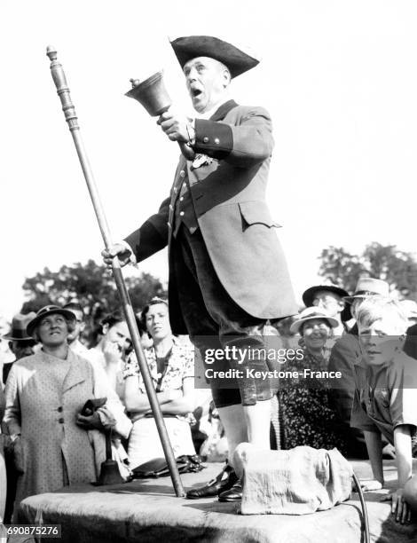 Un homme sur l'estrade, fait entendre sa voix aux juges lors du championnat de crieurs de rue, à Bodmin, Cornouailles, Royaume-Uni le 26 août 1937.