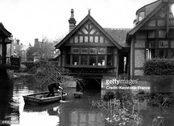 Un homme sur une barque arrive dans son jardin inondé, à Maidenhead, Royaume-Uni le 3 décembre 1946.