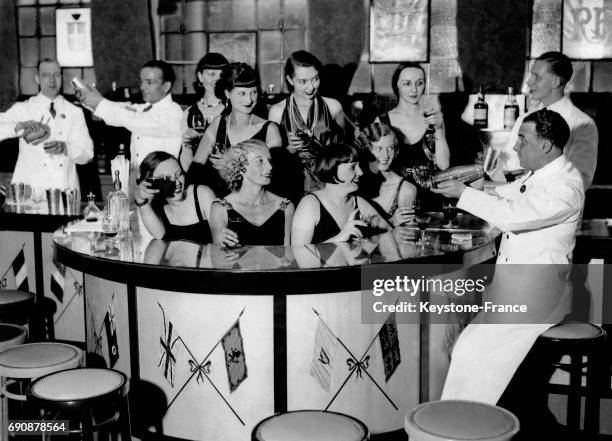 Les barmaids observent le barman mixer un cocktail avant l'ouverture du bar le plus international de la capitale britannique avec 15 membres du...