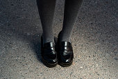 Retro Style Image Of School or student Girl's Feet In Uniform. black elegant shoes