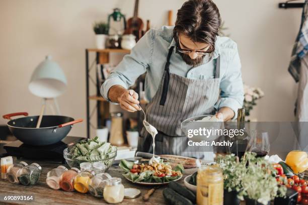 chef is adding sour cream topping on salad - hipster in a kitchen stock pictures, royalty-free photos & images