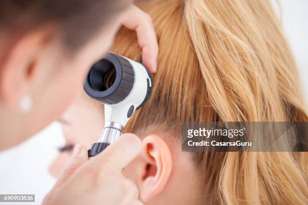 medico che ispeziona il cuoio capelluto del paziente con un dermatoscopio - dermatologia foto e immagini stock