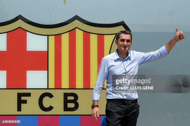 Barcelona's new coach Ernesto Valverde gives the thumbs up as he poses outside the Camp Nou stadium in Barcelona on May 31, 2017 prior to signing his...