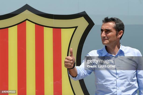 Barcelona's new coach Ernesto Valverde gives the thumbs up as he poses outside the Camp Nou stadium in Barcelona on May 31, 2017 prior to signing his...